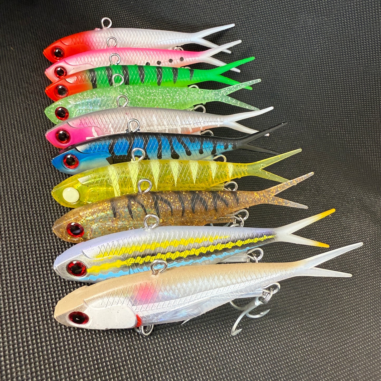 Assorted 115mm 45g Weapon Box lures in mixed bright colours – saltwater fishing vibes with strong trebles