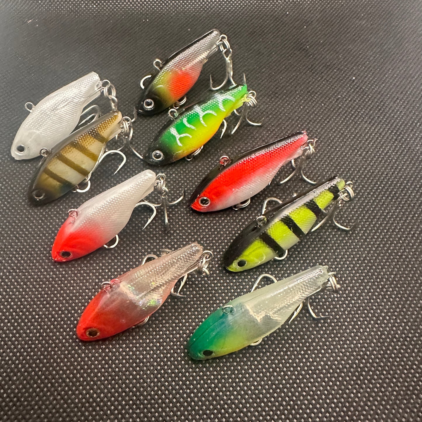 Assorted 9-pack of Reel Action Mask45 Vibe fishing lures in mixed colours, 45mm size, flat lay display.