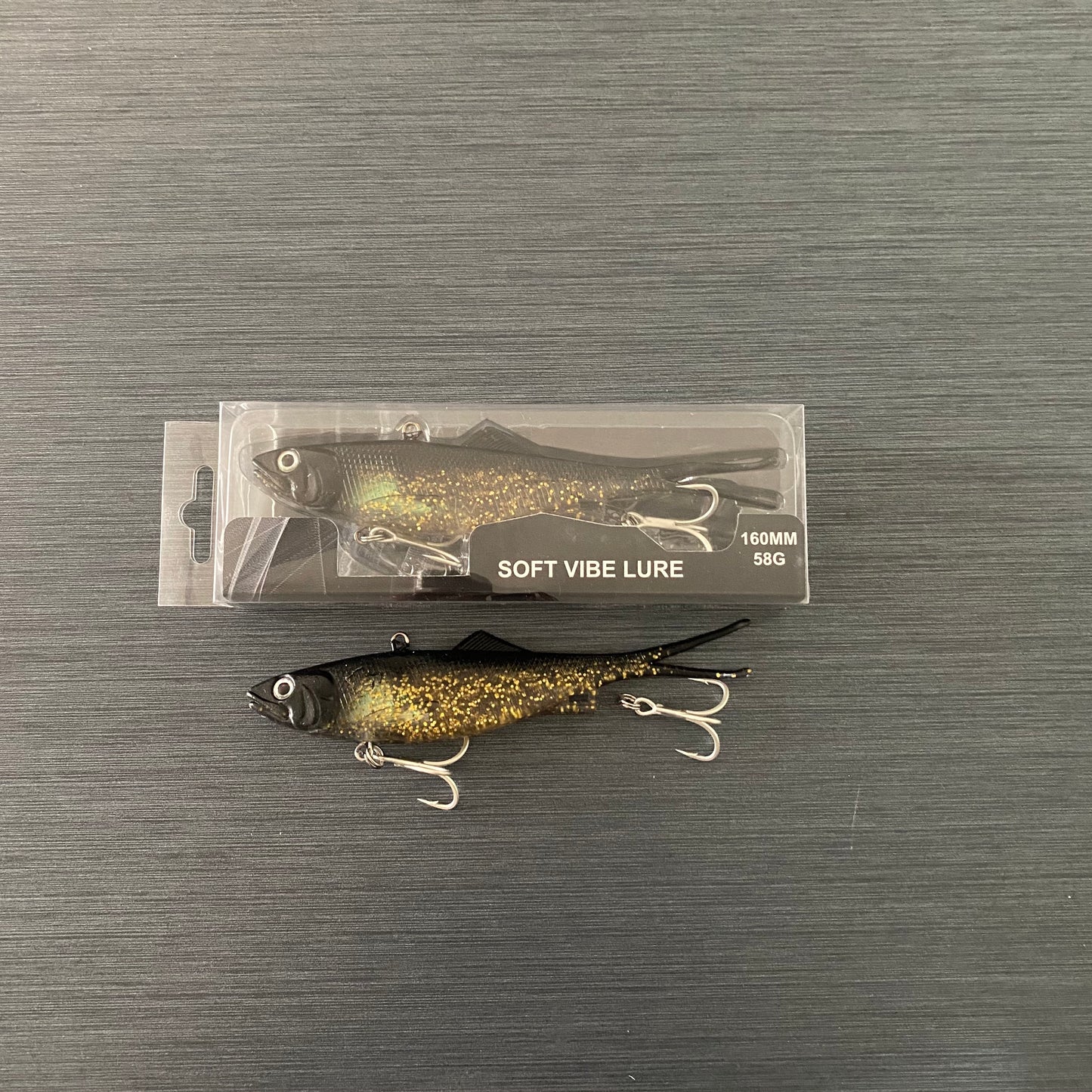 Side profile of packaged 160mm Black & Gold Reel Action Vibe fishing lure, ready for saltwater use.
